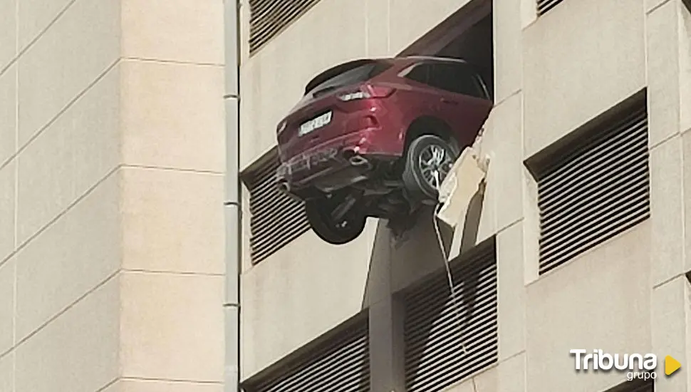 Da marcha atrás por error, rompe un muro y deja colgando el coche desde el tercer piso de un aparcamiento